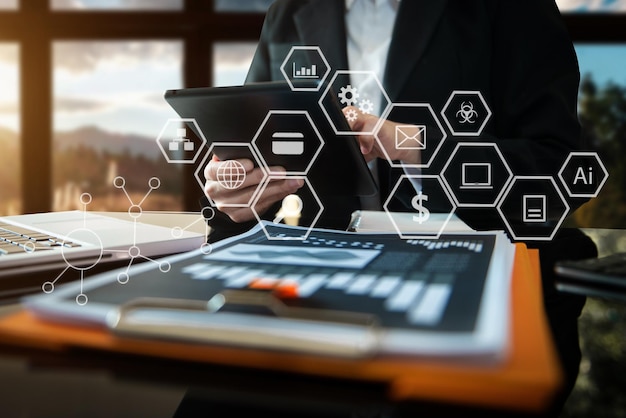 Imprenditrice mano utilizzando laptop, tablet e smartphone in ufficio. App mobile per i media di marketing digitale nella schermata dell'icona virtuale