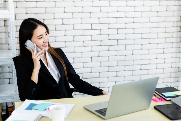 Imprenditrice parlando al telefono in ufficio