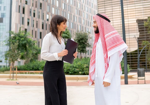 Imprenditrice parlando con uomo arabo in città