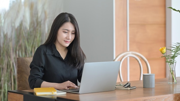 Imprenditrice professionista che lavora nel suo ufficio con un computer portatile