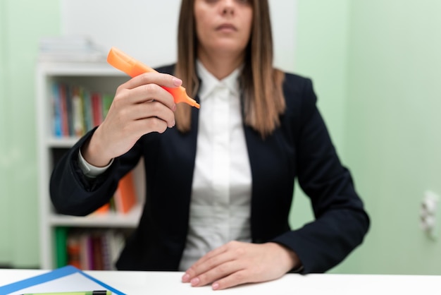 Imprenditrice tenendo il pennarello con una mano e indicando idee importanti Donna con penna colorata che mostra gli aggiornamenti recenti Executive che mostra le ultime notizie