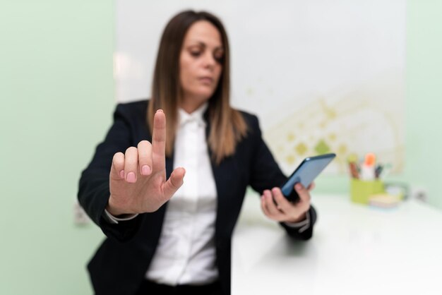 Imprenditrice tenendo il tablet con una mano e indicando idee importanti con un dito Donna con il telefono che mostra gli aggiornamenti recenti Executive che mostra le ultime notizie