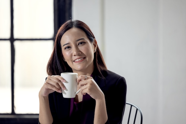 Imprenditrice tenendo la tazza di caffè in ufficio