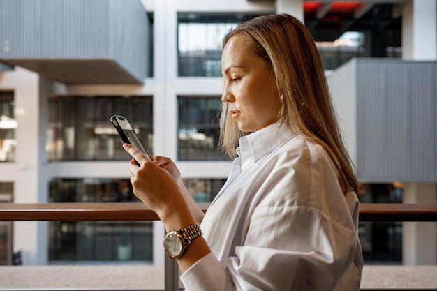 Imprenditrice usando il suo telefono cellulare sul balcone