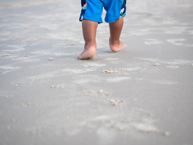 Impronta del bambino che cammina sulla spiaggia di sabbia