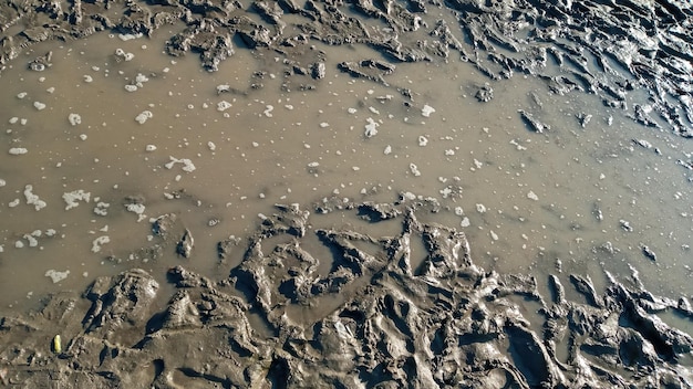 Impronta o impronta scarpa nel fangoTessuto fangoso o terreno marrone bagnato come argilla organica naturale e miscela di sedimenti geologici come sgrossatura in un terreno di campagna sporco e fangoso dopo la pioggia o la pioggia