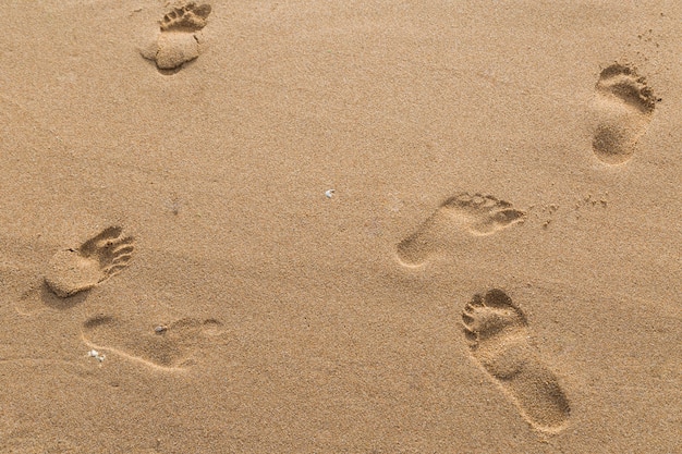 impronte di amanti nella sabbia sullo sfondo spiaggia