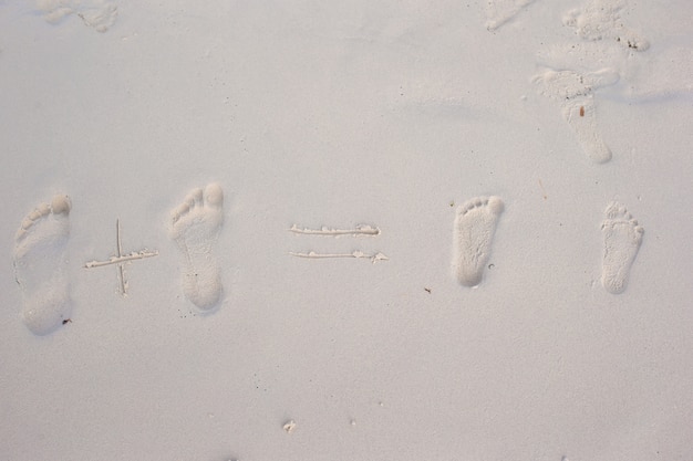 Impronte di famiglia sulla spiaggia di sabbia bianca