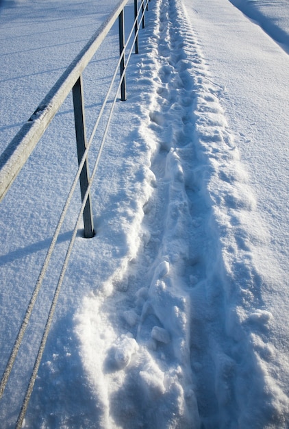 Impronte sui cumuli di neve dopo camminate, gelate e nevicate invernali