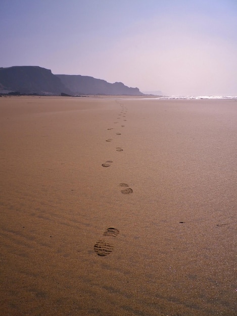 Impronte sulla sabbia sulla spiaggia contro il cielo