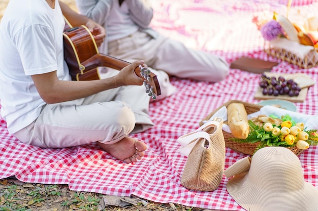 In amore coppia godendo tempo pic-nic nel parco all'aperto Picnic coppia felice rilassante insieme al cestino da picnic