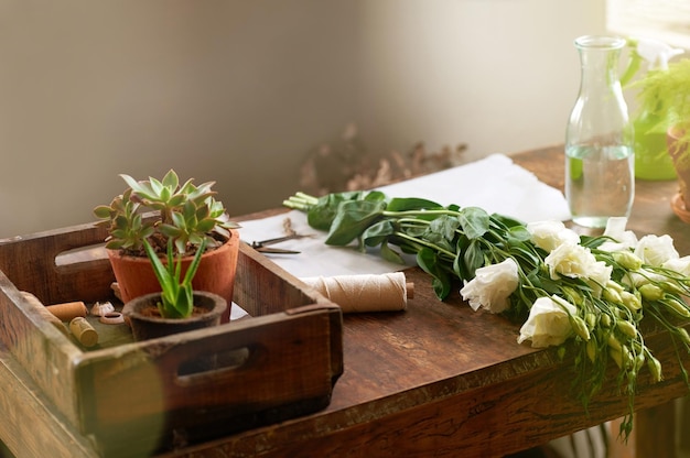 In attesa del loro posto nella tua casa Inquadratura di un mazzo di fiori e altre piante sdraiato sul tavolo da lavoro di un fiorista