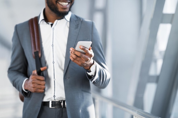 In attesa di imbarco uomo d'affari utilizzando il telefono nel terminal dell'aeroporto