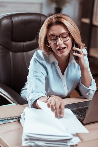 In cerca di rapporto. Avvocato dai capelli biondi che lavora sodo con gli occhiali che parla al telefono e cerca un rapporto