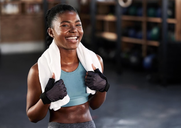 In forma e felice Scatto di una giovane donna sportiva in posa con un asciugamano intorno al collo in palestra