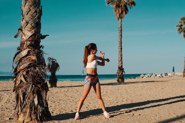 In forma e in salute. Integrale di bella giovane donna in abbigliamento sportivo che si allunga mentre si scalda all'aperto