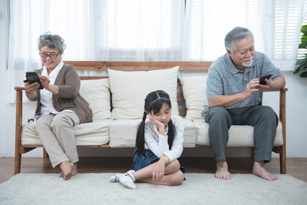 In lite anziano madre cresciuta figlia seduta sul divano separatamente con conflitti, incomprensioni intergenerazionali, nipote adulto nonna difficile cattive relazioni concetto di diverse generazioni