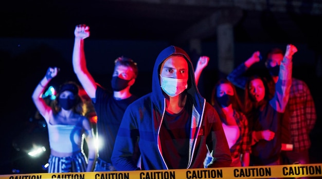 In maschere protettive Gruppo di giovani in protesta che stanno insieme Attivista per i diritti umani o contro il governo