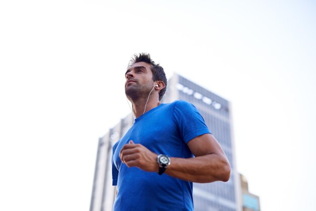 In movimento in città Inquadratura di un giovane che fa jogging per la città