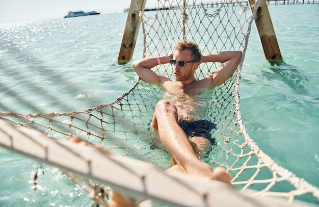 In occhiali da sole Il giovane europeo ha le vacanze e si gode il tempo libero sulla spiaggia del mare