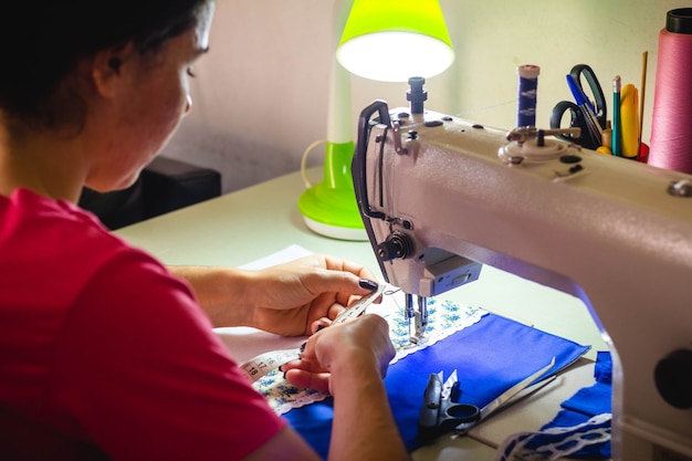 In questa illustrazione fotografica una sarta che lavora alla macchina da cucire nel laboratorio di moda.