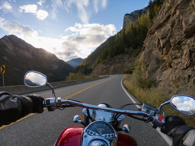 In sella a una moto su una strada panoramica circondata dalle montagne canadesi