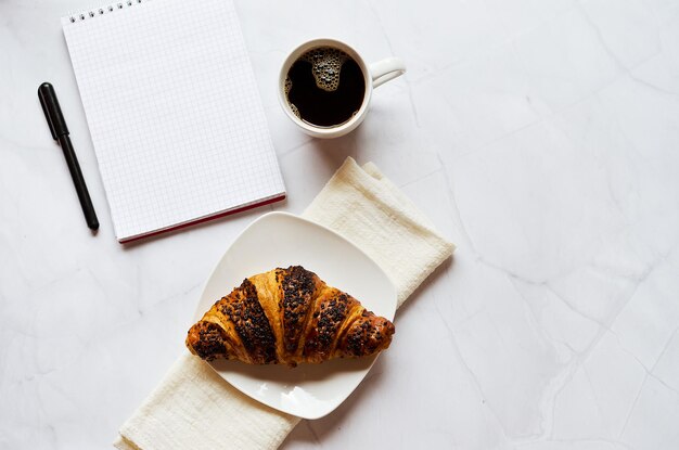 in su di caffè caldo e croissant su sfondo bianco. Vista dall'alto, copia spazio, mockup. Disposizione piatta. Sano