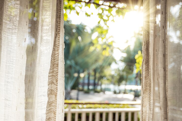 In the morning, the sun shines on the door through the white curtains.