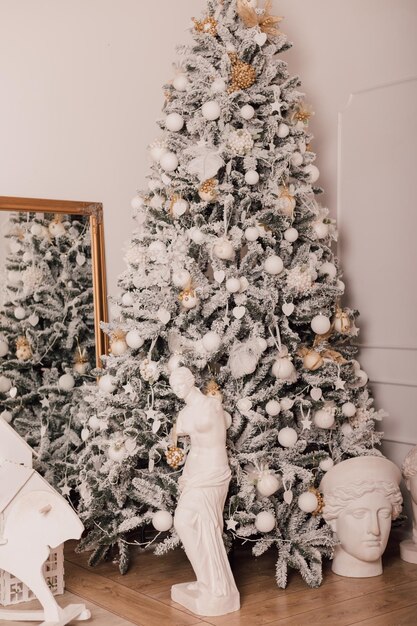 In un'accogliente stanza luminosa c'è un albero di Natale verde decorato con inrushki leggeri con regali