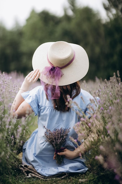 in un campo di lavanda una ragazza con un cappello