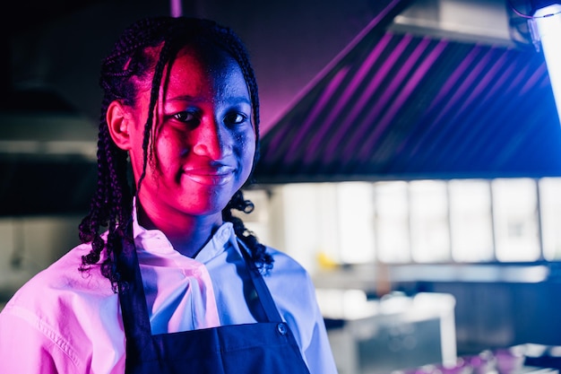 In un ristorante di cucina moderna una cuoca confida in uniforme sorride alla telecamera esperienza professionale di successo nella sua occupazione presentando cibo delizioso