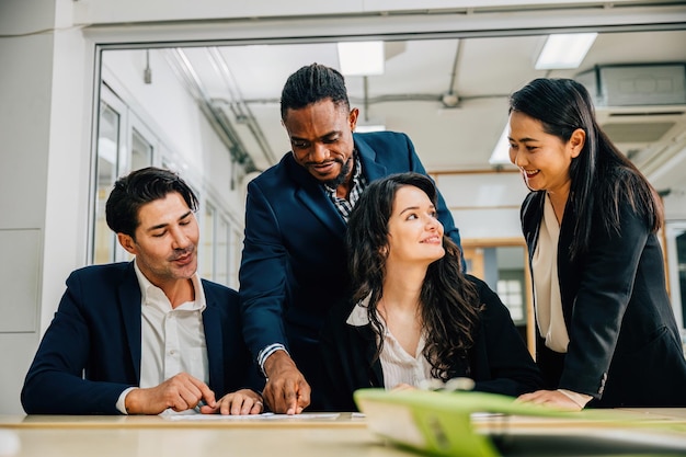 In una riunione globale, un team diversificato guidato da una capo donna si impegna in una vivace discussione. Insieme pianificano, collaborano e lavorano con documenti che mostrano il loro impegno per il successo.