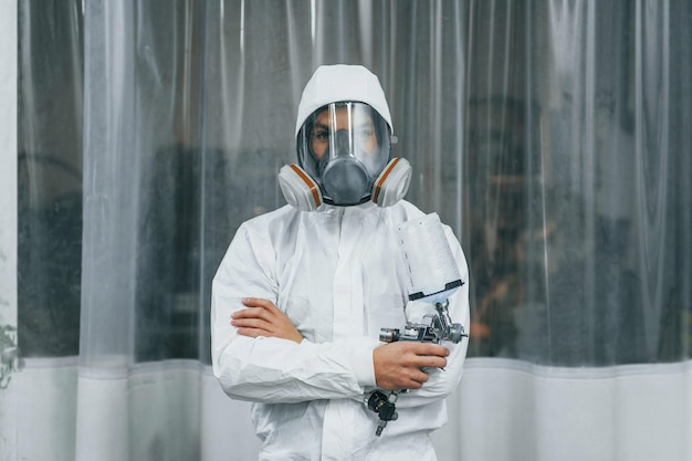 In uniforme bianca protettiva L'uomo sta lavorando nel servizio di auto