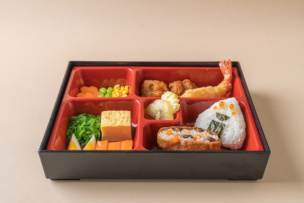 (inari sushi) riso sushi avvolto in tofu essiccato con gamberi fritti e pollo fritto in set bento