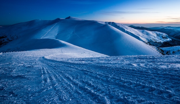 Incantevole vista stupenda sulle montagne e colline della valle innevata in tarda serata