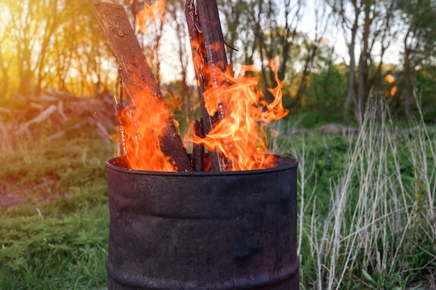 Incenerimento dei rifiuti in barile di metallo arrugginito.