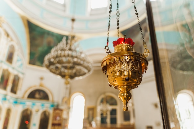 Incensiere d'oro con un candeliere rosso nella chiesa