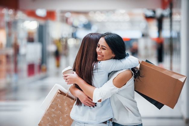 Incontro di due amiche nel centro commerciale durante lo shopping del fine settimana.