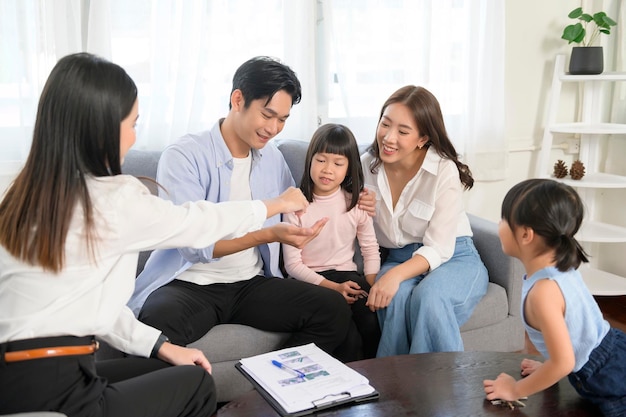 Incontro di famiglia asiatica con agente immobiliare femminile o consulente assicurativo che offre promozioni