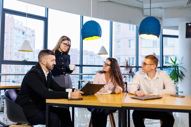 Incontro di uomini d'affari, discussione di nuove idee imprenditoriali, utilizzo di diagrammi, seduta insieme. Sfondo ufficio moderno. Incontro di partner commerciali a una conferenza sullo sviluppo aziendale