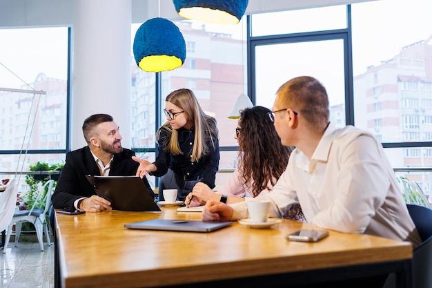 Incontro di uomini d'affari, discussione di nuove idee imprenditoriali, utilizzo di diagrammi, seduta insieme. Sfondo ufficio moderno. Incontro di partner commerciali a una conferenza sullo sviluppo aziendale