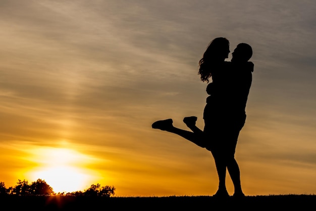 Incontro serale di amanti all'aperto ragazzo abbraccia la ragazza su uno sfondo del cielo serale romantico dat...