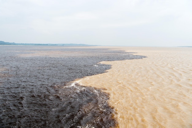 Incontro sull'acqua in brasile - fiume amazzonico con rio del negro acqua di fiume pulita e sporca con diversi corsi d'acqua