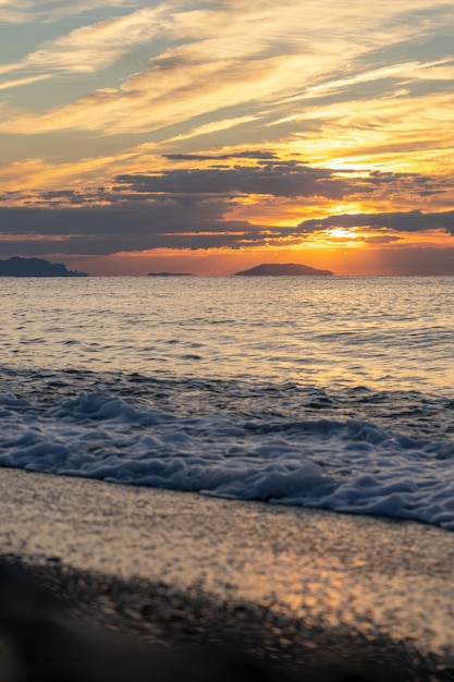 Incredibile alba sulla spiaggia tropicale. Sole giallo sul mare. Onde di colori arancioni. Sfondo della natura. Bella scena serena. Mattina. La luce del sole si riflette sulla superficie dell'acqua