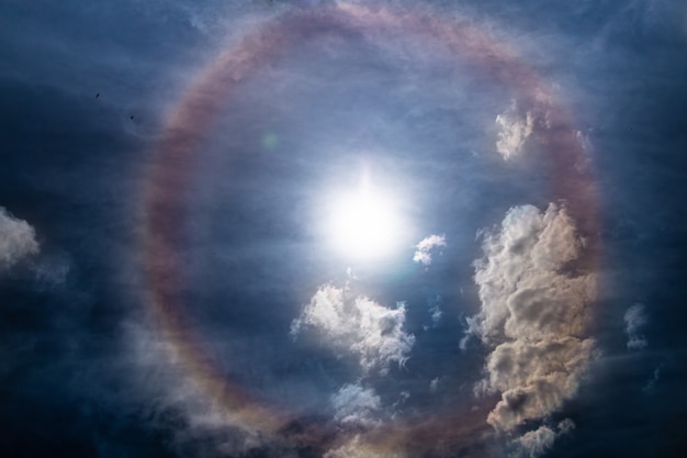 Incredibile anello arcobaleno intorno al sole in una giornata nuvolosaFantastico effetto solare naturale