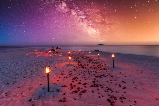 Incredibile cena in spiaggia sotto il cielo notturno di Milky Ways. Cena di lusso, luna di miele