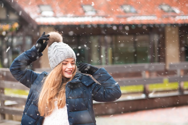 Incredibile donna rossa che cammina alla fiera invernale delle vacanze durante le nevicate. Spazio per il testo