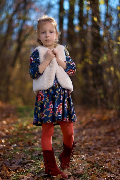 Incredibile foglia Ragazza carina in un grande mucchio di fogliame Bambina bambina piace giocare all'aria aperta