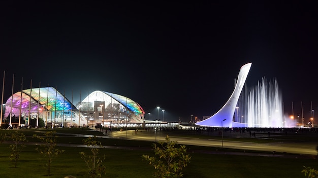 Incredibile fontana musicale illuminata e stadio olimpico "Fisht" di notte a Sochi, in Russia.