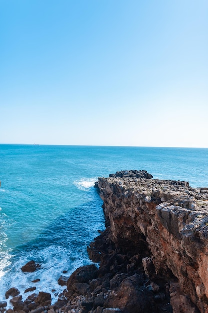 Incredibile oceano blu con onde rocciose e cielo blu chiaro